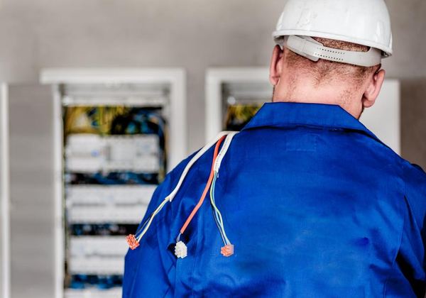 Électricien devant une armoire électrique